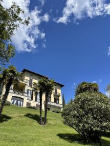 a building with palm trees in front of it at San Giusto I Villen-Ferienwohnung (EG) in Menaggio