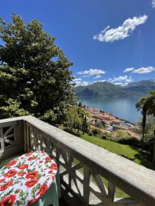 a table with a floral seat on a balcony with a view at San Giusto I Villen-Ferienwohnung (EG) in Menaggio
