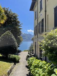 a path next to a building with a view of a lake at San Giusto I Villen-Ferienwohnung (EG) in Menaggio