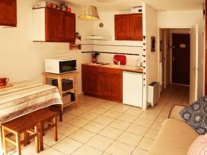 a kitchen with wooden cabinets and a table in a room at Studio Les Orres, 1 pièce, 4 personnes - FR-1-322-439 in Les Orres