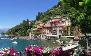 a group of houses on a river with flowers at Nido di Veronica See-Ferienwohnung in Bellano