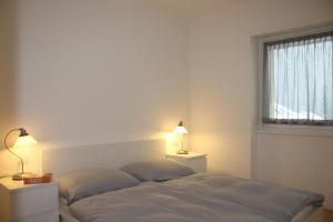 een slaapkamer met een bed met 2 kussens en een raam bij Rose Gialla Pastella Terrassen Ferienwohnung OG in Colico
