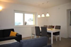 een woonkamer met een tafel en stoelen bij Rose Gialla Pastella Terrassen Ferienwohnung OG in Colico