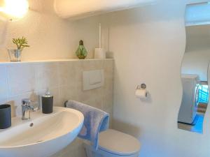 a white bathroom with a sink and a toilet at Panorama Ferienwohnung Lorenzo in Gera Lario
