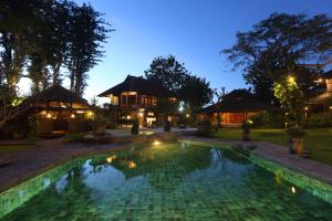 a large swimming pool in a tropical setting at Alindra Villa in Nusa Dua