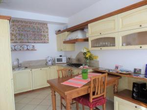 eine Küche mit einem Holztisch mit Stühlen und einem sidx sidx in der Unterkunft Nido di Mariangela See-Ferienwohnung in Bellano