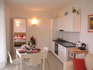 cocina y sala de estar con mesa y dormitorio con cama en Miralago Giardino EG-Ferienwohnung, en Gravedona