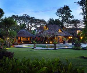 a house with a swimming pool in front of a yard at Alindra Villas & Spa in Nusa Dua