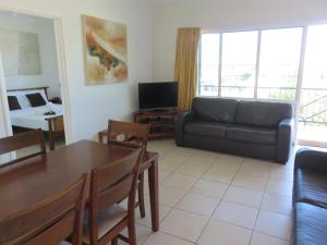 a living room filled with furniture and a tv at Airlie Beach Apartments in Airlie Beach