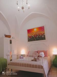 um quarto com uma cama com um quadro na parede em La loggetta 63 em Palagianello