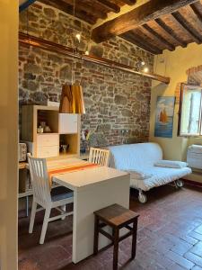 a room with a table and a desk and a bed at La Conchiglia in Scarlino