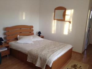a bedroom with a large bed with a wooden headboard at Pension Nicoleta in Costeşti