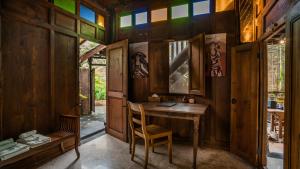 Habitación de madera con escritorio y silla en Yabbiekayu Eco-Bungalows, en Yogyakarta
