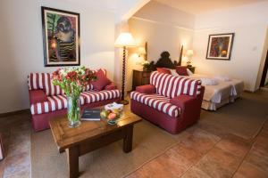 ein Hotelzimmer mit 2 Sofas und einem Bett in der Unterkunft Hotel Cala Sant Vicenç - Adults Only in Cala de Sant Vicent