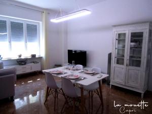 a white room with a dining room table and chairs at La Mouette di Nico in Capri