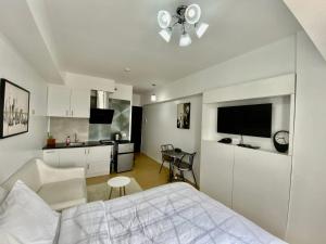 Biała sypialnia z łóżkiem i kuchnią w obiekcie Compact Studio Unit @ Centrio Tower w mieście Cagayan de Oro