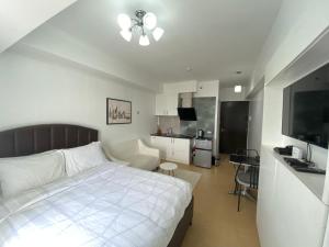 sypialnia z białym łóżkiem i kuchnią w obiekcie Compact Studio Unit @ Centrio Tower w mieście Cagayan de Oro