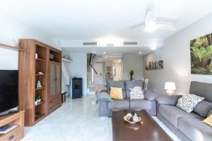 salon z kanapą i telewizorem w obiekcie Townhouse beachfront in Costalita w mieście Estepona