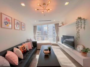 a living room with a black couch and a tv at LUX SUITES KL City Pavilion Bukit Bintang with INFINITY POOL in Kuala Lumpur