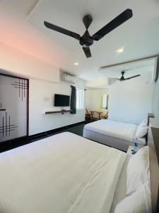 a bedroom with two beds and a ceiling fan at Villa Bordeaux in Puducherry