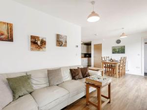 a living room with a white couch and a table at Lilac Lodge in Flaxley