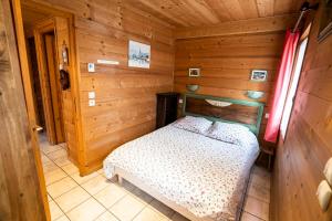 ein Schlafzimmer mit einem Bett in einer Holzhütte in der Unterkunft Igloo - Appartement 9 pers - Chatel Reservation in Châtel