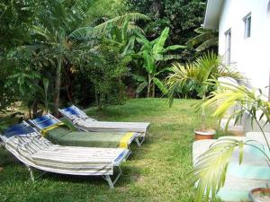 three lounge chairs in the grass next to a house at Chalets Anse Possession in Baie Sainte Anne