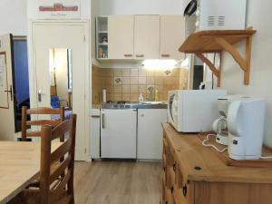 コトレにあるAppartement Cauterets, 3 pièces, 4 personnes - FR-1-234-139のキッチン(白いキャビネット、電子レンジ付きのカウンター付)