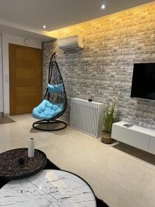 a living room with a hanging chair and a television at Superbe Appartement kantaoui sousse in Sousse