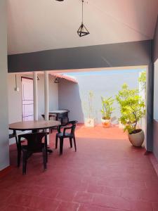 a dining room with tables and chairs and plants at Villa Bordeaux in Puducherry