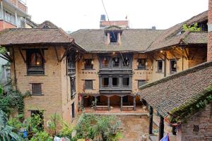帕坦Newa Chen Historic House UNESCO的中间有庭院的大型砖砌建筑