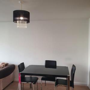 mesa de comedor con sillas negras y lámpara de araña en 2-bedroom Back Hilton Area apartment - Ground Floor, Aberdeen city center, en Aberdeen