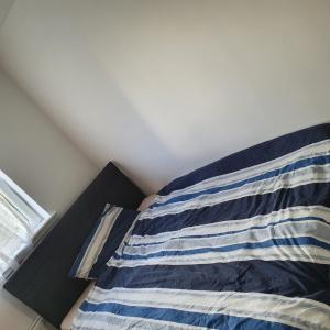 un letto con un cuscino a righe blu e bianche di 2-bedroom Back Hilton Area apartment - Ground Floor, Aberdeen city center ad Aberdeen