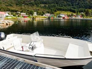 a white boat is docked on the water at 6 person holiday home in M L Y in Måløy