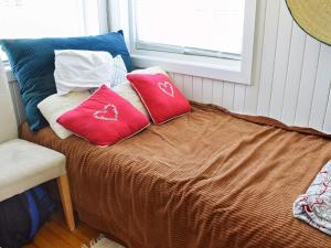 1 cama con almohadas rojas y ventana en Holiday home Hønefoss en Hønefoss