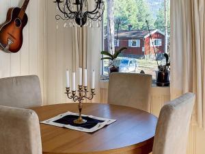 a dining room table with candles and a guitar at Holiday home Hønefoss in Hønefoss