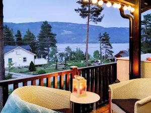 einen Balkon mit einem Tisch und Stühlen sowie Blick auf das Wasser in der Unterkunft Holiday home Hønefoss in Hønefoss