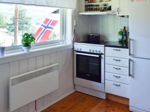 uma cozinha com um fogão branco e uma janela em Holiday home Hønefoss em Hønefoss