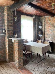 a room with a table and chairs and a brick wall at გურული ეზო*Gurian yard in Chala