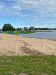 una playa de arena con agua y edificios de fondo en Frost Longstay Sundellsgatan 3 H en Haparanda