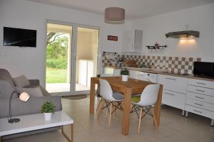 cocina y sala de estar con mesa y sofá en Appartement charmant en Corse avec terrasse au calme, en Santa-Lucia-di-Moriani