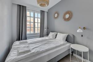 Habitación blanca con cama y ventana en Comfort Apartments Długi Targ, en Gdansk