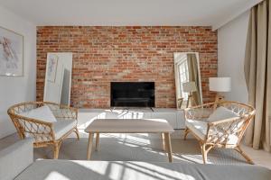 sala de estar con 2 sillas y pared de ladrillo en Comfort Apartments Długi Targ, en Gdansk