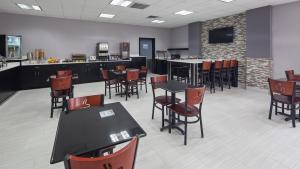 un restaurante con mesas y sillas y un bar en Clarion Pointe Jacksonville near Camp Lejeune en Jacksonville
