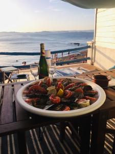 a plate of food on a table next to the beach at Chouette Cabanon sur la plage vue mer et terrasse privée in Marseille