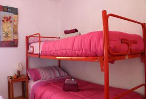 two bunk beds in a room with pink sheets at Appartamento La Foresta Abetone in Abetone