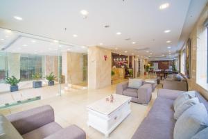 ダナンにあるQuoc Cuong Center Da Nang Hotel by Havilandのソファとコーヒーテーブル付きの広いロビー