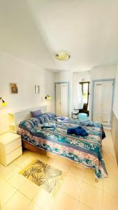 a bedroom with a large bed with a colorful blanket at Casa Ayla Montecastillo A8 in Caleta De Fuste