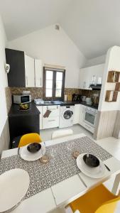 a kitchen with white cabinets and a table and chairs at Casa Ayla Montecastillo A8 in Caleta De Fuste