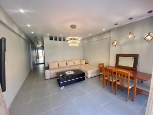 a living room with a couch and a table at Central Square Family Apartment in Nea Kallikrateia